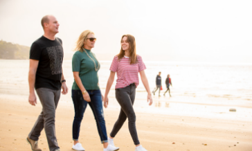 Brad and his family walking along the beach at Stanmore Bay