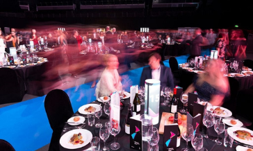 shot of a busy room on awards night. Dinner table in forground