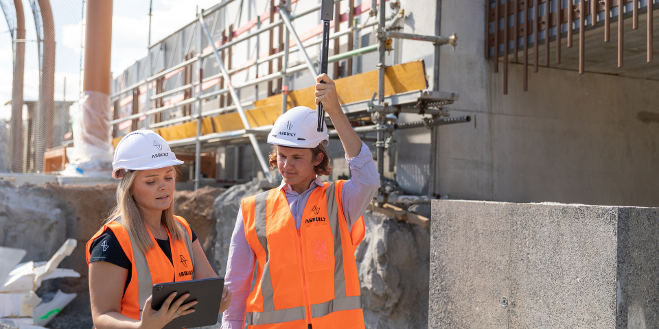 Man and women working on building site with tablet