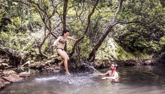 A couple relaxing in a natural hot pool in Auckland