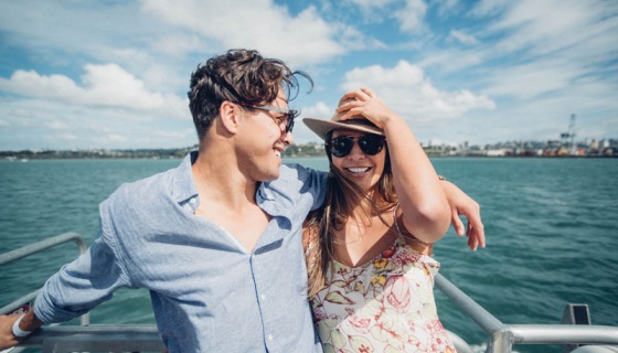 Couple smiling with Auckland Port in the background. 