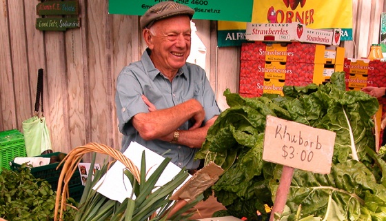 A happy vendor behind his fresh produce at Clevedon Markets